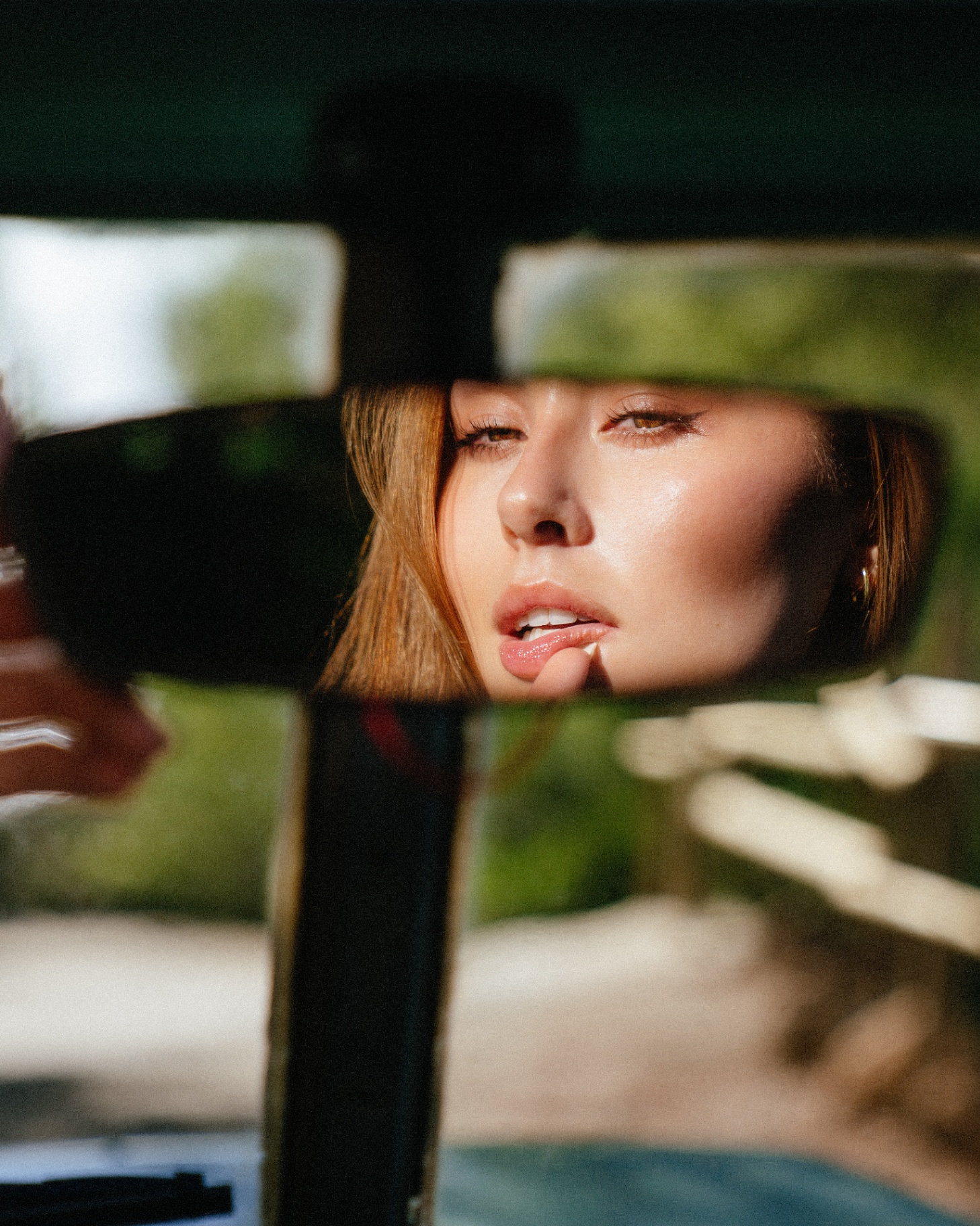 Portrait reflected in car rear-view mirror